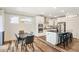 Well-lit kitchen with a large island, modern appliances, wood floors, and an adjacent dining area at 220 Green Haven Blvd, Youngsville, NC 27596