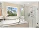 Luxurious main bathroom features a tub, shower, and a scenic window view at 220 Green Haven Blvd, Youngsville, NC 27596