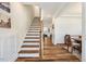 Elegant staircase featuring hardwood steps, white risers, and stylish wainscoting along the walls at 220 Green Haven Blvd, Youngsville, NC 27596