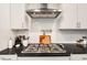 Close-up of the kitchen stovetop with stainless steel hood and a light backsplash at 220 Green Haven Blvd, Youngsville, NC 27596