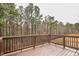 Private back deck with wood railings, offering a serene view of the surrounding lush greenery and trees at 240 Amber Acorn Ave, Raleigh, NC 27603