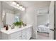 Bright bathroom with dual sinks, white cabinetry, and doorway to bedroom at 240 Amber Acorn Ave, Raleigh, NC 27603
