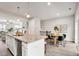Open-concept dining area with modern table set, artwork, and seamless flow to kitchen at 240 Amber Acorn Ave, Raleigh, NC 27603