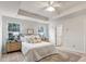 Bright main bedroom with tray ceiling, neutral decor, and ensuite bathroom at 240 Amber Acorn Ave, Raleigh, NC 27603