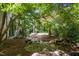 Tranquil backyard showcasing a meandering stream, mature trees, and the home's stately exterior at 2658 Davis St, Raleigh, NC 27608