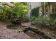 Scenic view of a backyard stream surrounded by lush greenery and the home's elegant architecture at 2658 Davis St, Raleigh, NC 27608