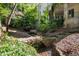 Picturesque backyard featuring a charming stone bridge over a small stream and lush, mature landscaping at 2658 Davis St, Raleigh, NC 27608