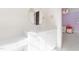 Bathroom vanity featuring a round mirror, white cabinets, and access to the purple themed bedroom at 2658 Davis St, Raleigh, NC 27608