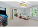 Light-filled bedroom with a bed, an arcade game, a view to a seating area, and neutral color palette at 2658 Davis St, Raleigh, NC 27608