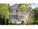 Rear exterior showcasing a brick facade, arched windows, and a large covered patio with lush greenery at 2658 Davis St, Raleigh, NC 27608