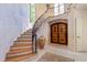 Elegant foyer featuring curved staircase, a stone archway and wood paneled doors at 2658 Davis St, Raleigh, NC 27608