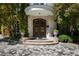 Close up of the stone entryway featuring a wrought iron doorway and mature landscaping at 2658 Davis St, Raleigh, NC 27608