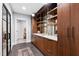 Hallway with dark wooden cabinets, open shelves with decorative glasses, and a marble countertop at 2658 Davis St, Raleigh, NC 27608