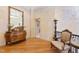 Upper level landing with hardwood floors, an antique dresser with mirror, and a comfortable seating area at 2658 Davis St, Raleigh, NC 27608