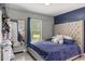 Cozy bedroom with a tufted headboard, blue bedding, and a window offering natural light at 2728 Old Milburnie Rd Rd, Raleigh, NC 27604