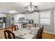 Bright kitchen and dining area with white cabinets, stainless steel appliances, and a stylish light fixture at 2728 Old Milburnie Rd Rd, Raleigh, NC 27604