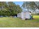 Backyard with two sheds and a blue classic car in a sunny outdoor setting at 2728 Old Milburnie Rd Rd, Raleigh, NC 27604