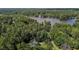 Breathtaking aerial view of a lake surrounded by lush forest, with a home nestled in the landscape, accessible by a private drive at 276 Sagamore Dr, Louisburg, NC 27549