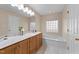 Bathroom boasts wood cabinets, marble countertop, and a built-in tub at 276 Sagamore Dr, Louisburg, NC 27549
