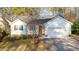 A charming one-story home featuring a spacious two-car garage, complemented by mature landscaping and a paved driveway at 276 Sagamore Dr, Louisburg, NC 27549