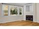 Living room with hardwood floors, fireplace, and large windows providing natural light at 276 Sagamore Dr, Louisburg, NC 27549