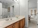 Bathroom featuring a double sink vanity with wood cabinets and large mirror at 3025 Osterley St, Raleigh, NC 27614