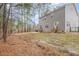 Large backyard with two-story home, bare lawn, and wooded border at 3102 Seth Dr, Sanford, NC 27330