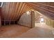 Unfinished attic with exposed beams, wood floor, insulation, and door showcases potential for storage or expansion at 3471 Wagon Wheel Rd, Rocky Mount, NC 27804