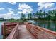 Wooden pier with a seating area overlooking a calm lake and a distant fountain at 349 Shadow Falls Dr, Wendell, NC 27591