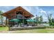 Outdoor lounge area with a wooden pavilion, patio seating, and views of a scenic pond at 349 Shadow Falls Dr, Wendell, NC 27591