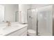 Bright bathroom featuring a white vanity with solid-surface countertop and subway-tiled shower with glass doors at 349 Shadow Falls Dr, Wendell, NC 27591