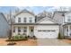 Charming two-story home with white siding, a covered porch, and a two-car garage, creating a welcoming curb appeal at 349 Shadow Falls Dr, Wendell, NC 27591