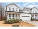 Charming two-story home with white siding, a covered porch, and a two-car garage, creating a welcoming curb appeal at 349 Shadow Falls Dr, Wendell, NC 27591