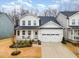 Charming two-story home with white siding, a covered porch, and a two-car garage, creating a welcoming curb appeal at 349 Shadow Falls Dr, Wendell, NC 27591