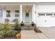 Inviting front porch with a stylish entry door, classic white columns, and meticulously manicured landscaping at 349 Shadow Falls Dr, Wendell, NC 27591