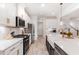Bright kitchen features white cabinets, stainless appliances, quartz counters, and a farmhouse sink at 349 Shadow Falls Dr, Wendell, NC 27591
