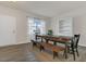 Bright dining room featuring hardwood floors and a wooden table with bench seating by a sunny window at 3512 Dragonfly River Ct, Raleigh, NC 27604