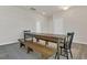 Dining room showcasing a long wooden table with a bench and chairs set on a neutral rug over wood floors at 3512 Dragonfly River Ct, Raleigh, NC 27604