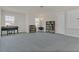 Spacious carpeted living room with piano, bookshelves, and natural light at 3512 Dragonfly River Ct, Raleigh, NC 27604