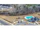 An aerial shot of a sparkling community pool, playground, clubhouse, and parking area, surrounded by lush greenery at 3512 Dragonfly River Ct, Raleigh, NC 27604