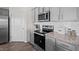 Modern kitchen featuring gray cabinets, granite countertops, stainless steel appliances, and stylish backsplash at 369 Swift Creek Farm Ln, Clayton, NC 27520