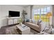 Bright living room with a large window, comfortable seating, stylish decor, and a modern entertainment center at 369 Swift Creek Farm Ln, Clayton, NC 27520