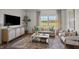 Cozy living room featuring a comfortable sofa, stylish armchairs, large window, and decorative furnishings at 369 Swift Creek Farm Ln, Clayton, NC 27520