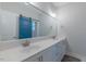 Bathroom featuring a double vanity, large mirror, and a stylish blue barn door accent at 375 Thomas Arnold Rd, Zebulon, NC 27597