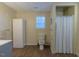 A bathroom with a toilet, shower with curtain, window, and cabinet at 375 Thomas Arnold Rd, Zebulon, NC 27597