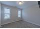 Bedroom with neutral carpeting, bright white trim, and two windows, offering a versatile space at 375 Thomas Arnold Rd, Zebulon, NC 27597