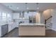 Open concept kitchen featuring an island, granite countertops, stainless appliances, white cabinetry, and a view of the staircase at 375 Thomas Arnold Rd, Zebulon, NC 27597
