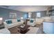 A well lit, open concept living area with white modern furniture and sleek minimalist interior design and kitchen at 375 Thomas Arnold Rd, Zebulon, NC 27597