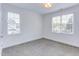 Bright bedroom features two windows, light gray carpet, white walls, and modern lighting at 415 Westbury Dr, Chapel Hill, NC 27516