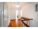 Hallway with hardwood floors, white walls, and stairway at 513 E Franklin St, Chapel Hill, NC 27514